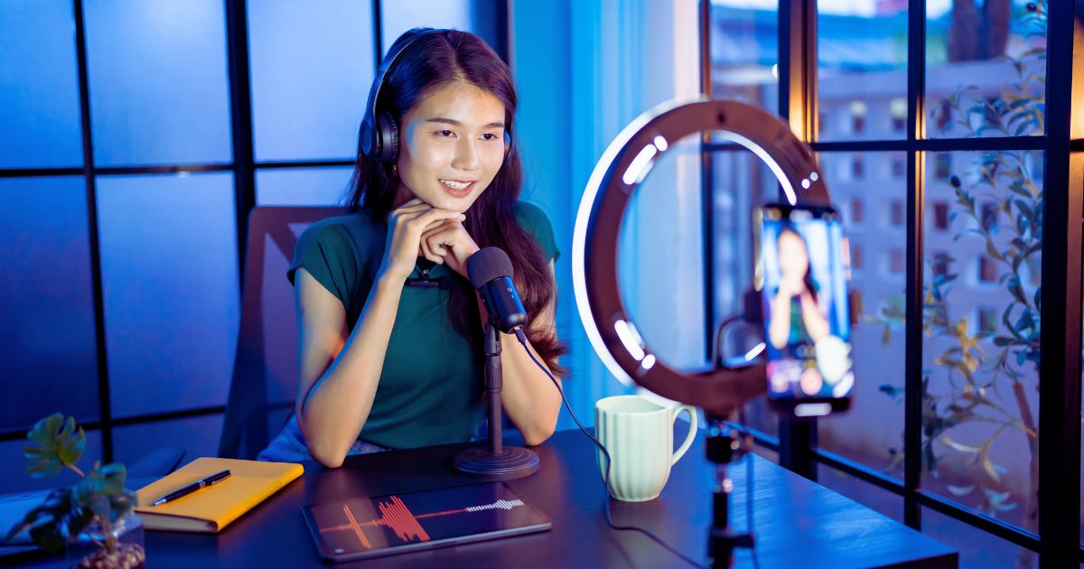 Mulher gravando vdeo em um estdio moderno, com equipamentos de iluminao e cmera profissional, simbolizando a criao de produtos digitais lucrativos