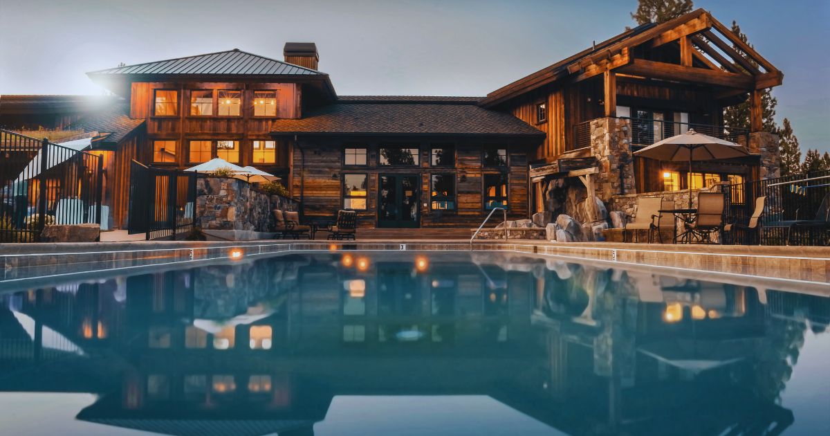Mansão luxuosa com piscina ampla e elegante em primeiro plano, representando o estilo de vida das famílias mais ricas do mundo.
