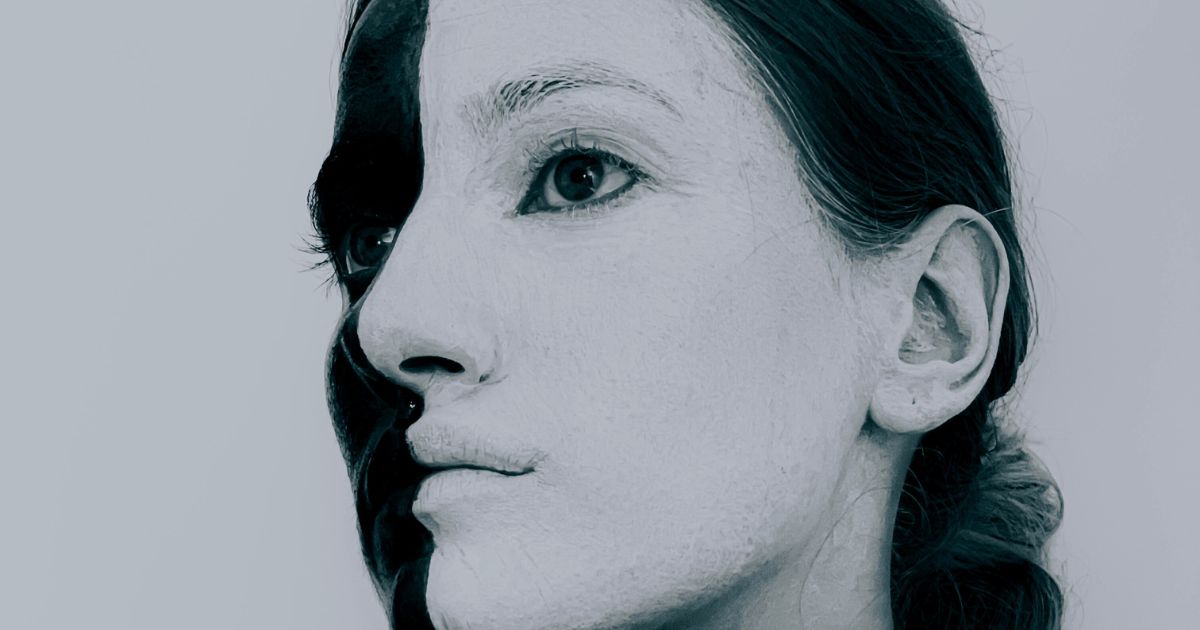 Rosto de uma mulher em preto e branco, metade claro e metade escuro, simbolizando a construção da identidade e do branding pessoal.