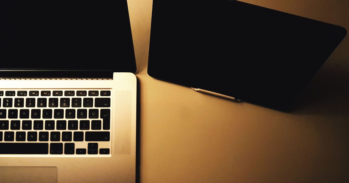 Foto tirada de cima mostrando notebook e tablet sobre uma mesa, representando estratégias de marketing digital para 2026.