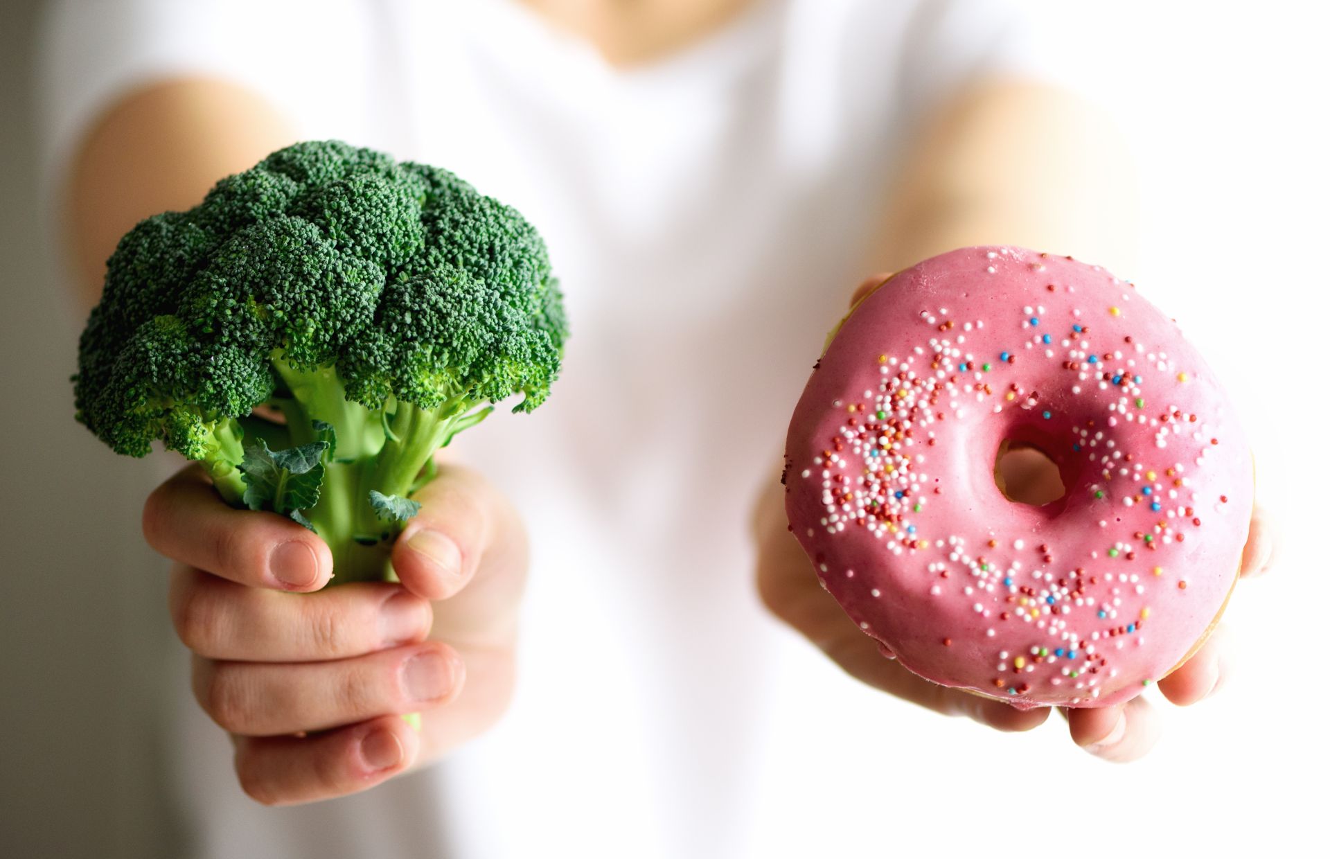 Willpower isn't the answer to binge eating Person wondering whether to eat broccoli or donut