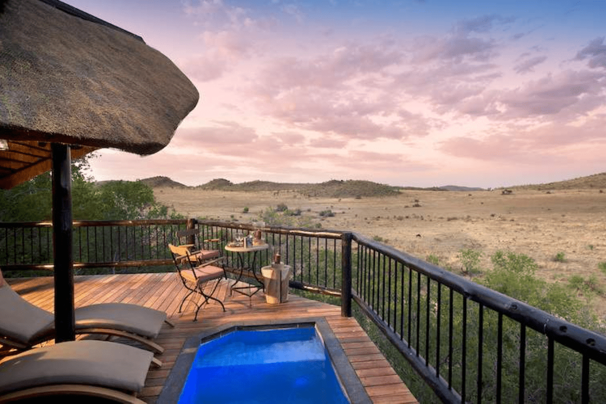 a deck with a pool and a thatched roof